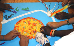 photo of childrens' hands on a poster model of a comet orbit