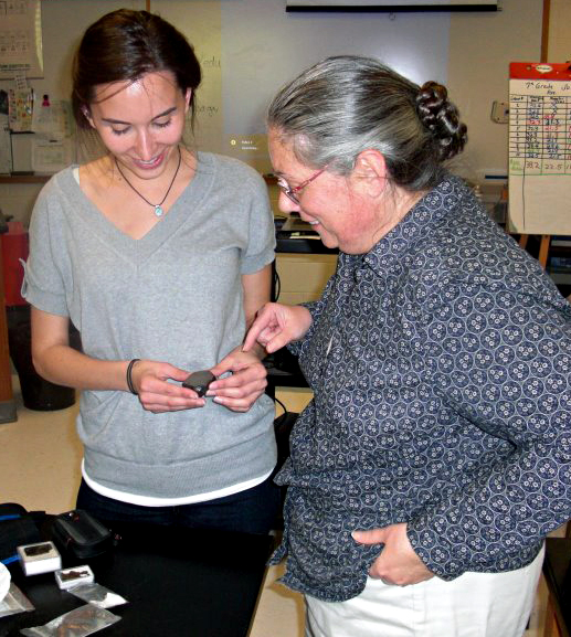 Carolyn showing a meteorite to teacher.