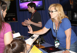 Aimee Meyer talks with guests about how EPOXI and Stardust-NExT are repurposed spacecraft. Jeff Pinner (background) also talks about the missions.